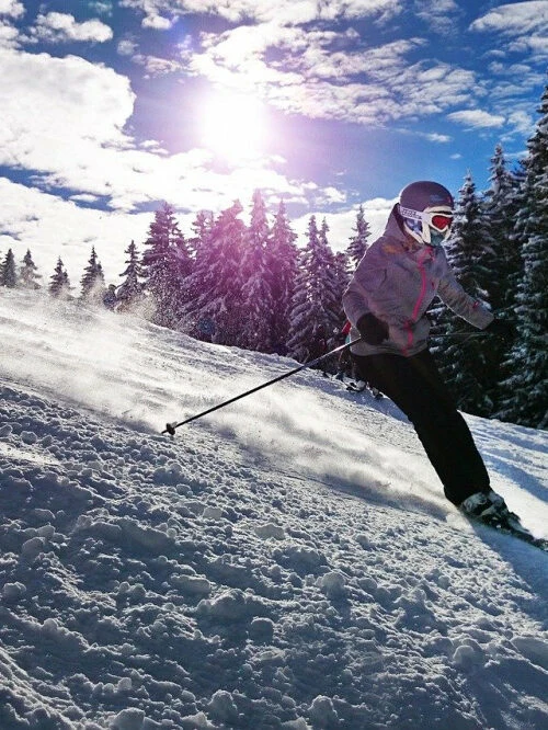 Lyžařka na upravené sjezdovce za slunečného zimního dne – skiareál Šacberk